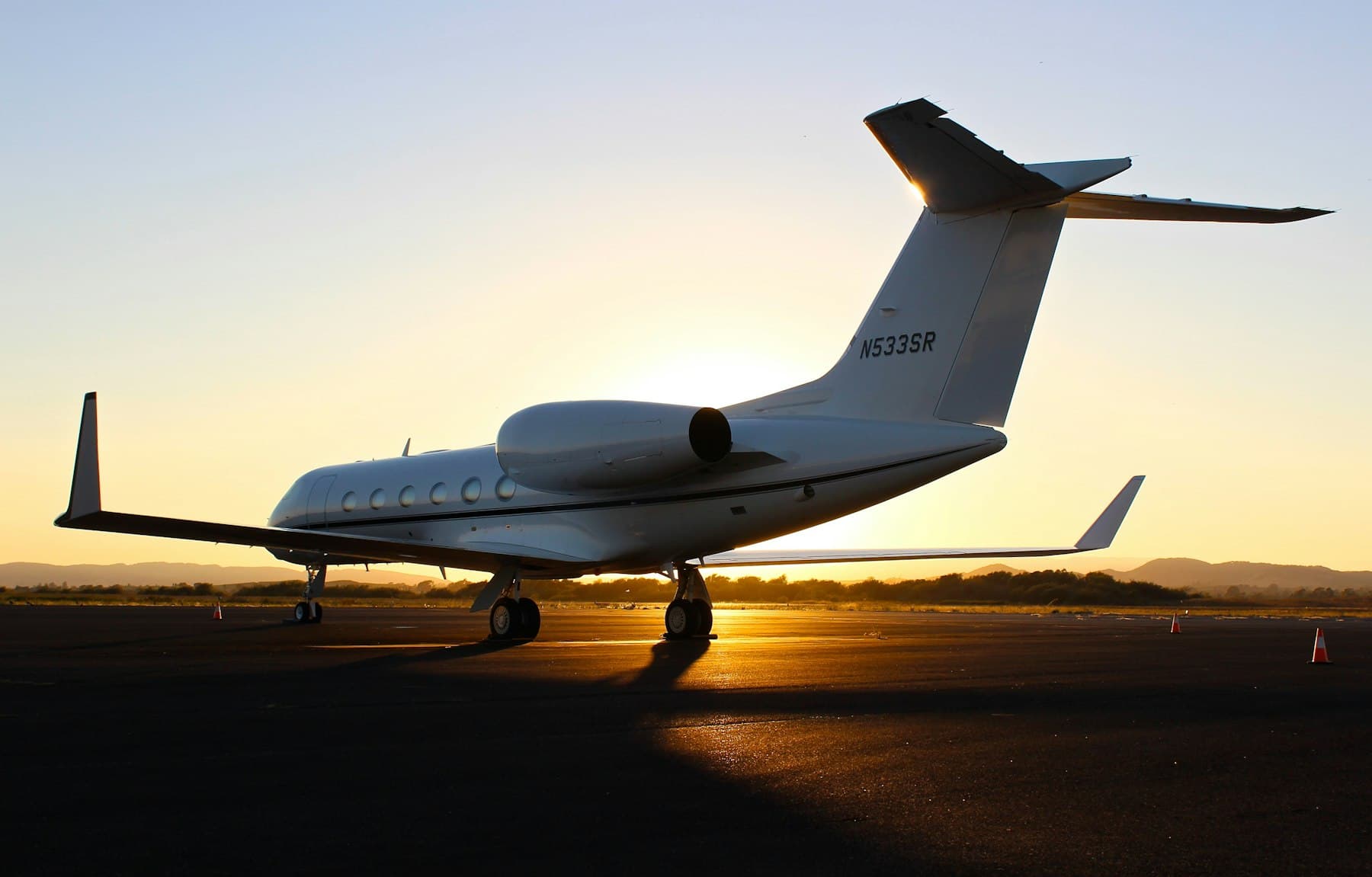 Avión privado en pista al atardecer